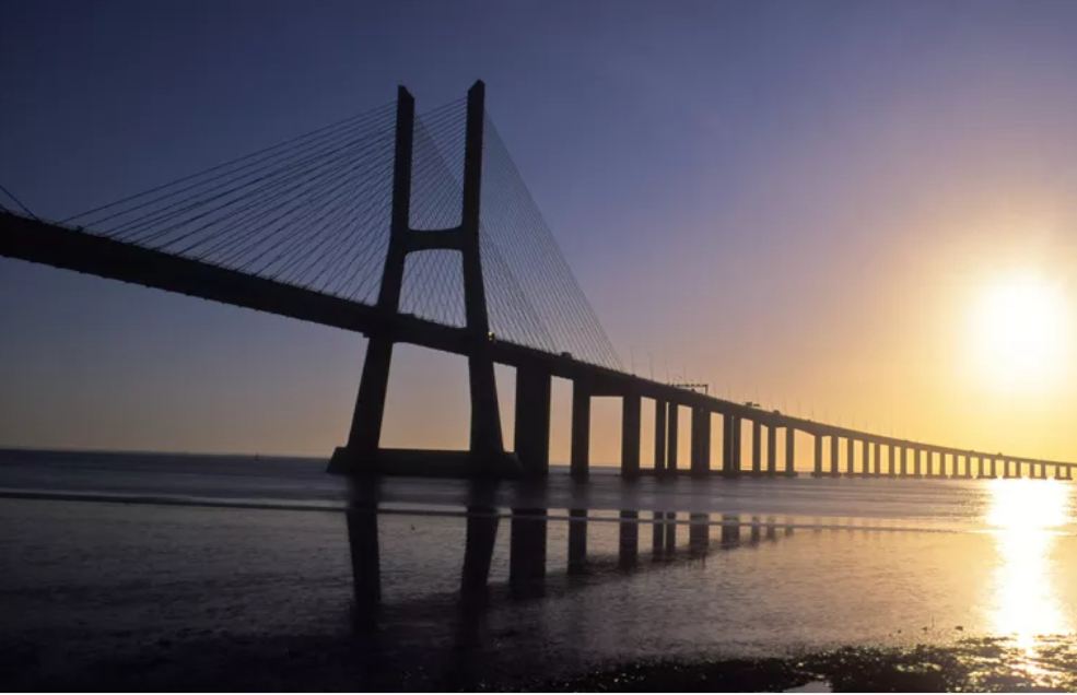 Ponte strallato lungo sedici chilometri con il sole che si riflette nell'acqua